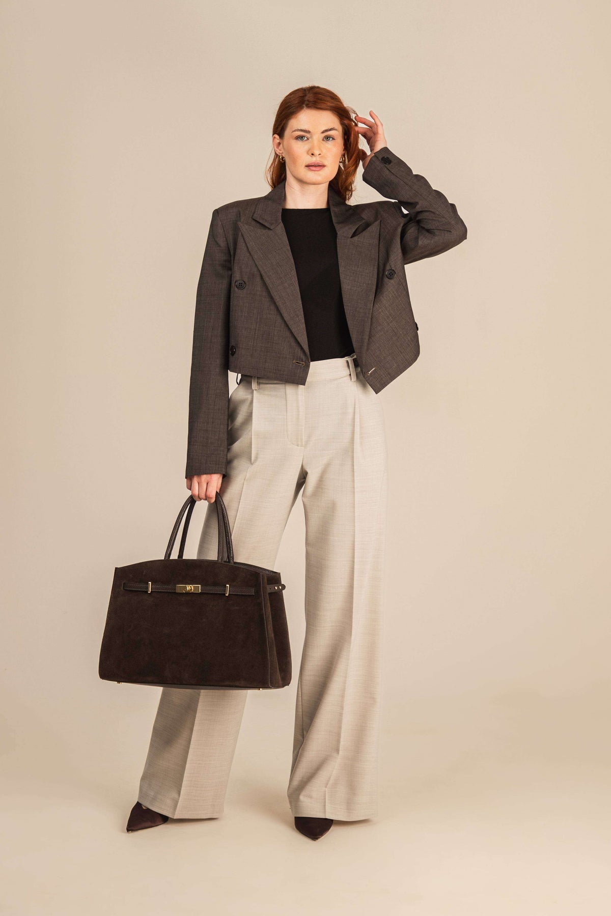 Spodnie damskie z kantem z wełny w eleganckim zestawieniu z marynarką i dużą torebką 