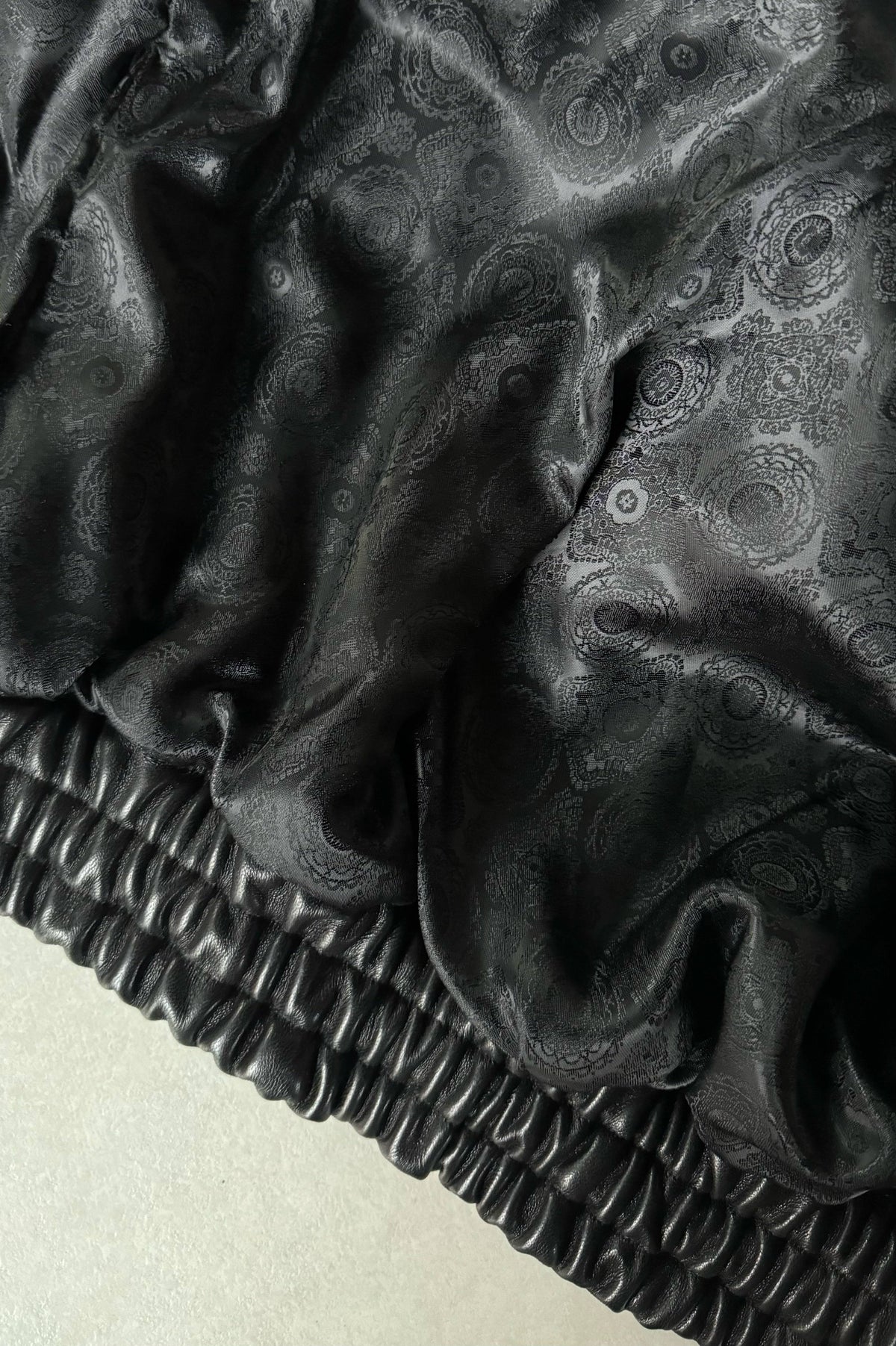 Czarna skórzana kurtka w stylu lat 90. oversize - zblizenie artystycznie wykonaną podszewkę z wiskozy